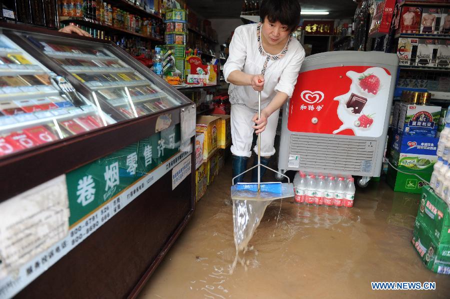 A woman cleans her flooded shop on the Fusheng Road of Nanchang, capital of east China's Jiangxi Province, May 14, 2013. A heavy rainfall hit Jiangxi Province on May 14. The average rainfall of the province reached 46.4 millimeters, with that of Nanchang climbing to the highest of 71 millimeters May 15. (Xinhua/Yuan Zheng)