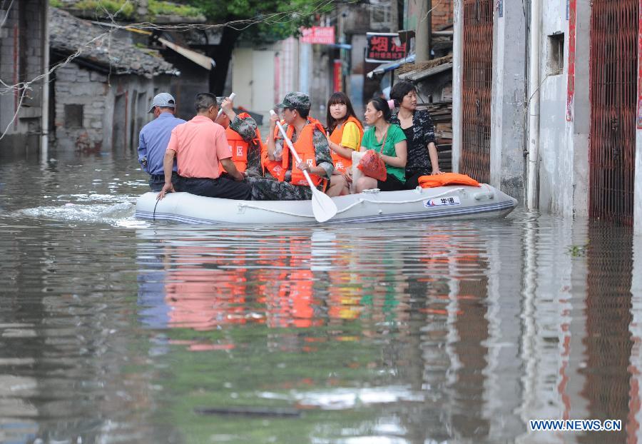Rescuers evacuate the stranded residents on the old Jingshan Street in Nanchang City, capital of east China's Jiangxi Province, May 14, 2013. A heavy rainfall hit Jiangxi Province on May 14. The average rainfall of the province reached 46.4 millimeters, with that of Nanchang climbing to the highest of 71 millimeters May 15. (Xinhua/Yuan Zheng)