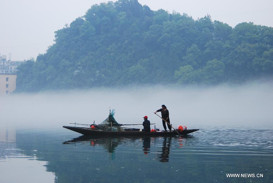 Fisherman steer a boat through fogs on the Xin'an River in Jiande, east China's Zhejiang Province, May 15, 2013. (Xinhua/Ning Wenwu) 