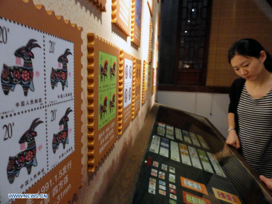 A visitor appreciates zodiac stamps in the Suzhou Zodiac Stamp Museum in Suzhou, east China's Jiangsu Province, May 15, 2013. The museum, which will be opened to the public free of charge on May 18, stores zodiac stamps which were issued in more than 100 countries and regions since 1950. (Xinhua/Wang Jiankang)