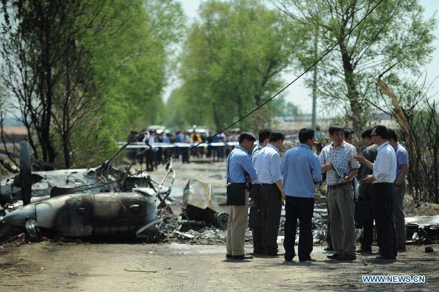 Investigators work beside the remains of a light plane after it failed to take off at Taoxian Airport in Shenyang, capital of northeast China's Liaoning Province, May 16, 2013. Three people on board were injured in the accident on Thursday. (Xinhua/Pan Yulong) 