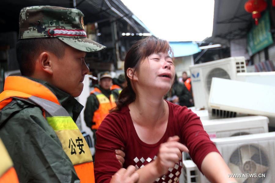A relative of victim cries at the site of a landslide in Xiamen, southeast China's Fujian Province, May 16, 2013. Torrential rainfall triggered a landslide at the Qianpu Flea Market in Xiamen early May 16, causing one adult and two children dead. (Xinhua/Zeng Demeng) 