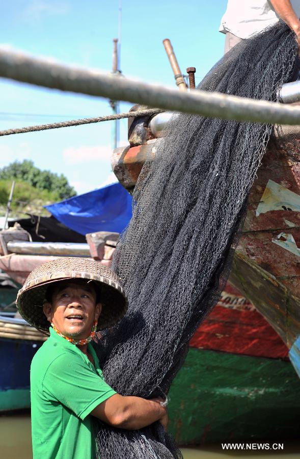 Fisherfolks work on their fishing nets before the annual fishing moratorium starts at Gangbei port in Wanning City, south China's Hainan Province, May 16, 2013. The annual fishing moratorium in Hainan lasts from May 16 to Aug. 1 each year. This year marks the 15th year of fishing moratorium here, and in total 9,007 fishing boats as well as 34,780 fisherfolks are involved. (Xinhua/Shi Manke) 