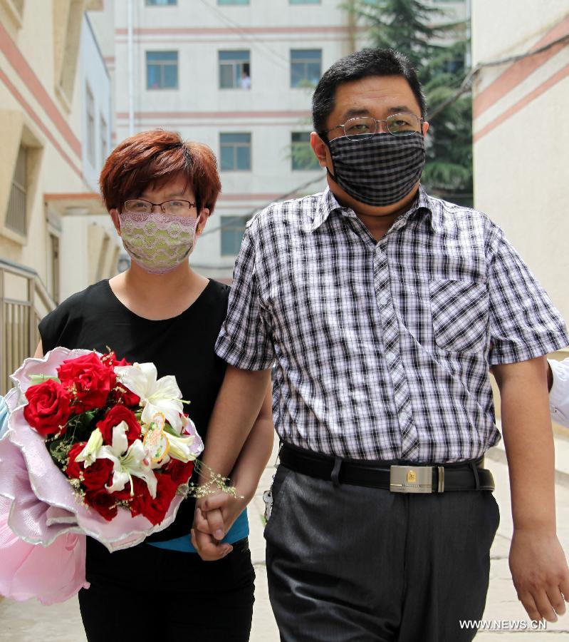 The H7N9 bird flu patient surnamed Zhang (R) walks out of the Zaozhuang Municipal Hospital in Zaozhuang City, east China's Shandong Province, March 16, 2013. Zhang has recovered from the disease as the first H7N9 bird flu infection in Shandong Province. (Xinhua/Sun Zhongzhe) 