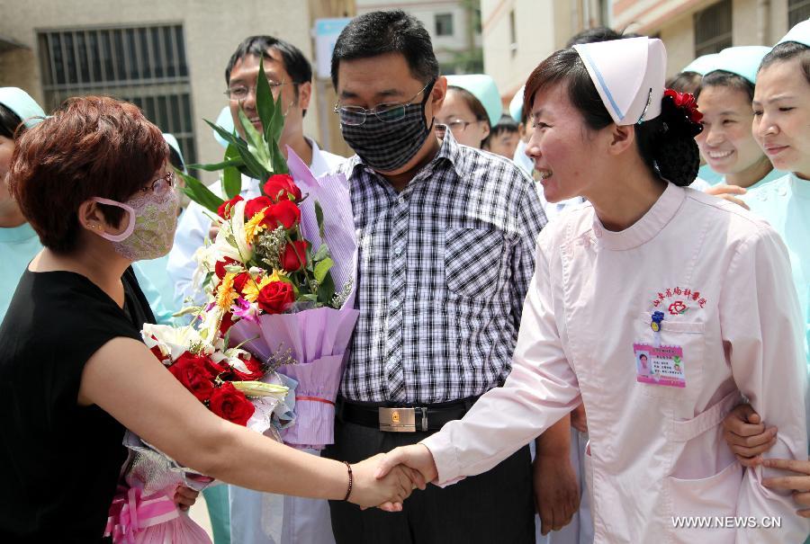 The wife (L) of the H7N9 bird flu patient surnamed Zhang (2nd R) shakes hands with a medical staff member at the Zaozhuang Municipal Hospital in Zaozhuang City, east China's Shandong Province, March 16, 2013. Zhang has recovered from the disease as the first H7N9 bird flu infection in Shandong Province. (Xinhua/Sun Zhongzhe) 