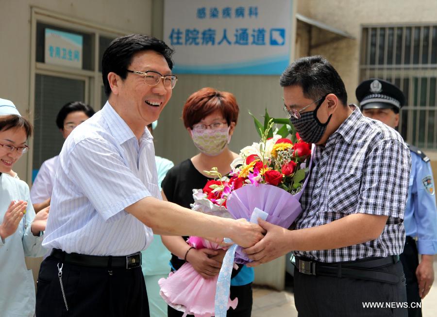 The H7N9 bird flu patient surnamed Zhang (R) receives flowers from a medical staff member at Zaozhuang Municipal Hospital in Zaozhuang City, east China's Shandong Province, March 16, 2013. Zhang has recovered from the disease as the first H7N9 bird flu infection in Shandong Province. (Xinhua/Sun Zhongzhe) 