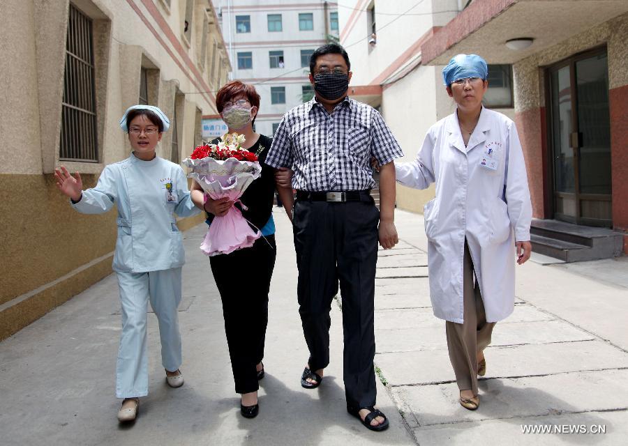 The H7N9 bird flu patient surnamed Zhang (2nd R) and his wife (3rd R) walk out of the Zaozhuang Municipal Hospital with medical staff members in Zaozhuang City, east China's Shandong Province, March 16, 2013. Zhang has recovered from the disease as the first H7N9 bird flu infection in Shandong Province. (Xinhua/Sun Zhongzhe)