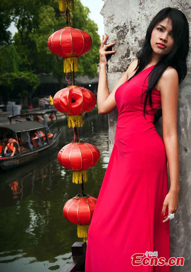 A contestant of the 2013 Miss Tourism International poses for photos in evening dress in Xitang, an ancient town in East China's Zhejiang Province, May 15, 2013. (CNS/Qian Xingqiang)