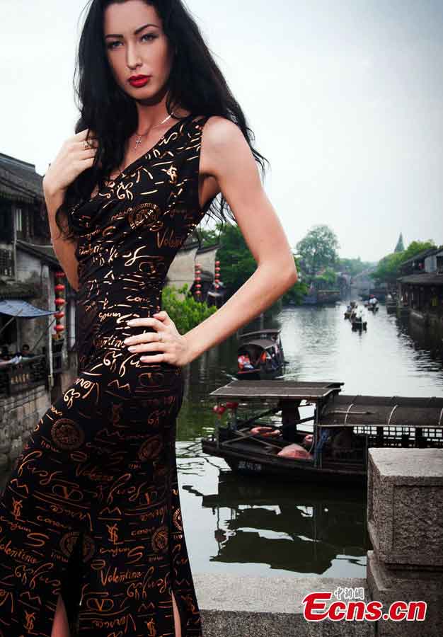 A contestant of the 2013 Miss Tourism International poses for photos in evening dress in Xitang, an ancient town in East China's Zhejiang Province, May 15, 2013. (CNS/Qian Xingqiang)