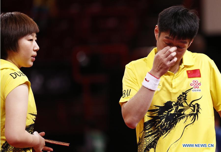 Qiu Yike (R) and Wen Jia of China react during the round of 16 of mixed doubles against Jiang Tianyi and Lee Ho Ching from Hong Kong of China at the 2013 World Table Tennis Championships in Paris, France on May 16, 2013. Qiu Yike and Wen Jia lost 2-4. (Xinhua/Wang Lili)