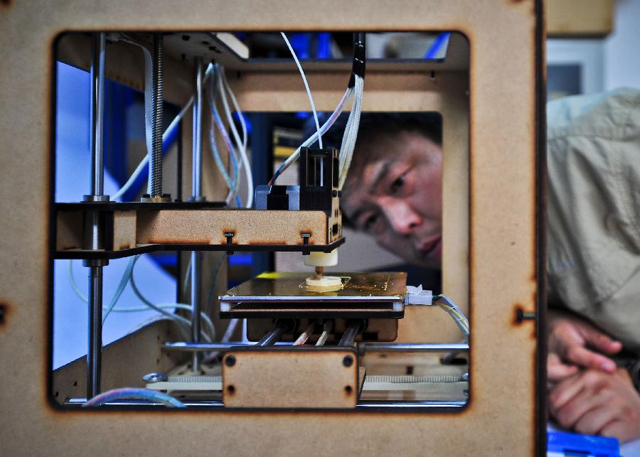Han Bing uses his handmade 3D printer to make an item in Tianjin Municipality, north China, May 16, 2013. Based on the method released on the internet, the 41-year-old by himself made this machine eventually, which costing some 2,000 RMB yuan (325 U.S. dollars) and spending four months. At present, Han's 3D printer could only make simple items designed on the computer, like teapots and whistles. And he hopes his creation could function more powerfully by continuous improvement. (Xinhua/Zhang Chaoqun) 
