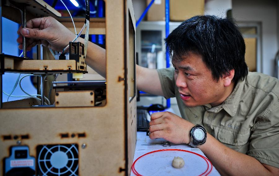 Han Bing adjusts his handmade 3D printer in Tianjin Municipality, north China, May 16, 2013. Based on the method released on the internet, the 41-year-old by himself made this machine eventually, which costing some 2,000 RMB yuan (325 U.S. dollars) and spending four months. At present, Han's 3D printer could only make simple items designed on the computer, like teapots and whistles. And he hopes his creation could function more powerfully by continuous improvement. (Xinhua/Zhang Chaoqun) 