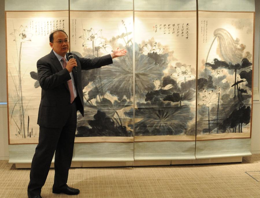 A working staff introduces a painting of Zhang Daqian during the preview of Christie's spring season auction in south China's Hong Kong, May 16, 2013. The auction will be held in Hong Kong from May 25 to 29 this year. (Xinhua/Wong Pun Keung)  