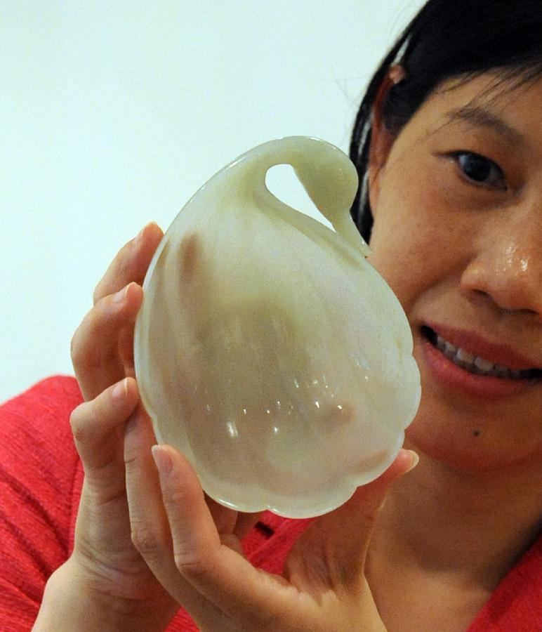 A working staff introduces a white jade product of Qing Dynasty (1644-1912) during the preview of Christie's spring season auction in south China's Hong Kong, May 16, 2013. The auction will be held in Hong Kong from May 25 to 29 this year. (Xinhua/Wong Pun Keung)  