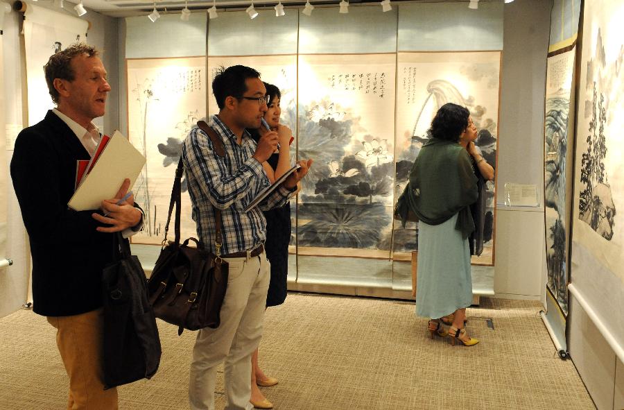 Visitors watch paintings during the preview of Christie's spring season auction in south China's Hong Kong, May 16, 2013. The auction will be held in Hong Kong from May 25 to 29 this year. (Xinhua/Wong Pun Keung)  
