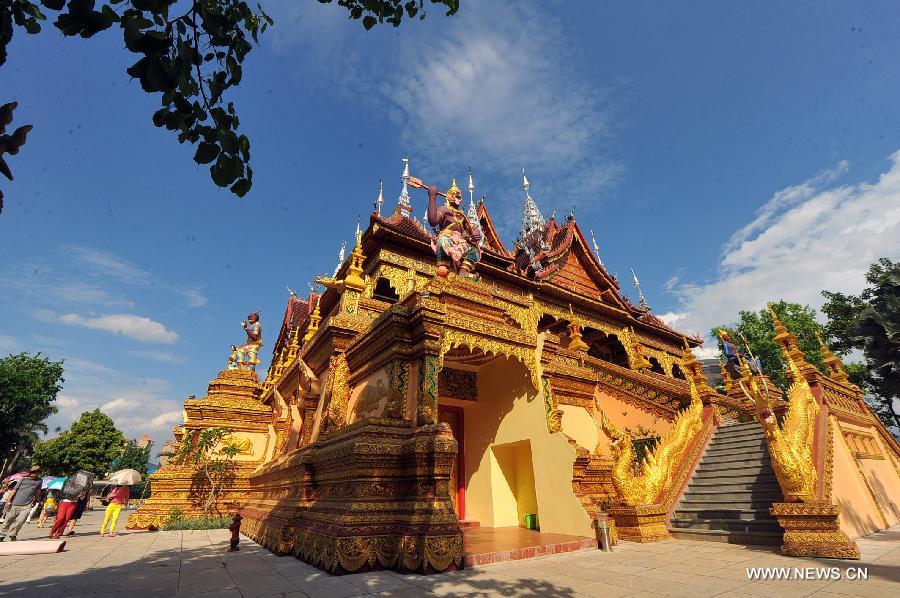 Tourists visit the Zongfo Temple in Jinghong of Xishuangbanna Prefecture in southwest China's Yunnan Province, May 16, 2013. The Zongfo Temple, which covers an area of more than 3,000 square meters and has a history of over 1,000 years, has seen completion of its overhaul and is now open free to the public. (Xinhua/Chen Haining) 