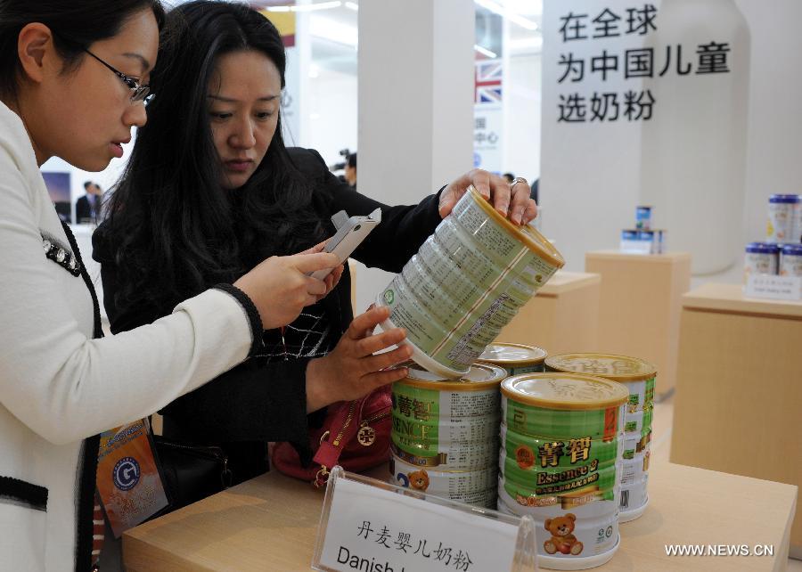 Dealers collect the information of some Danish milk powder on display in the Taizhou Global Commodity Purchasing Center in Taizhou City, east China's Jiangsu Province, May 16, 2013. The center, with a total investment of 200 million RMB yuan (about 32 million dollars), opened here on Friday and will provide services mainly to eastern China provinces of Jiangsu, Shandong and Anhui. (Xinhua/Luo Zhongming) 