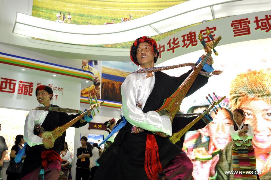 Performers from southwest China's Tibet Autonomous Region perform at the region's pavilion on the 9th China International Cultural Industries Fair (ICIF) in Shenzhen, south China's Guangdong Province, May 17, 2013. The four-day ICIF kicked off on Friday here, attracting over two thousand exhibitors. (Xinhua/Liang Xu) 