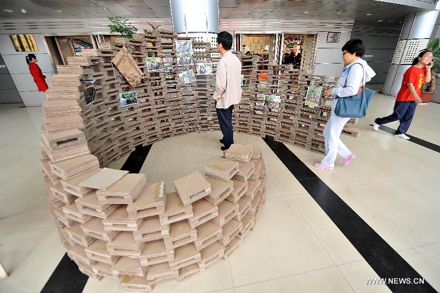 Students look at a sculpture made of waste cardboard at the 2013 creativity fair in Taiyuan University of Technology in Taiyuan, capital of north China's Shanxi Province, May 17, 2013. (Xinhua/Zhan Yan)