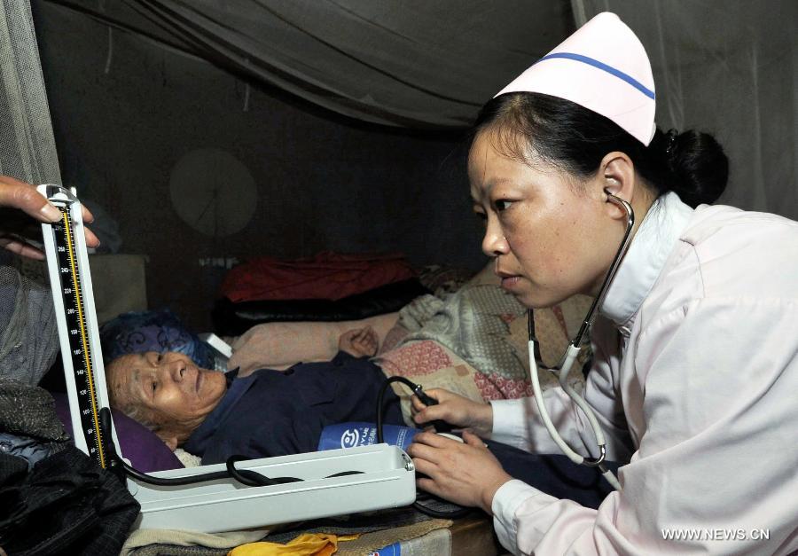 A medical worker checks the physical condition of a 85-year-old patient named Wang Chengzhou in Daishan County, Zhoushan City, east China's Zhejiang Province, May 17, 2013. A medical service team, formed by medical workers from the Zhoushan detachment of the provincial Frontier Defence Department and some doctors from the local Red Cross Society, provided free medical treatments to residents here on Friday. (Xinhua/Xu Yu)  