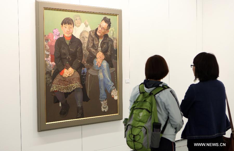 Visitors watch oil painting works by Chinese realistic painter Xin Dongwang at an exhibition of Xin Dongwang's works in Beijing, capital of China, May 17, 2013. (Xinhua/Zhang Yanhui) 