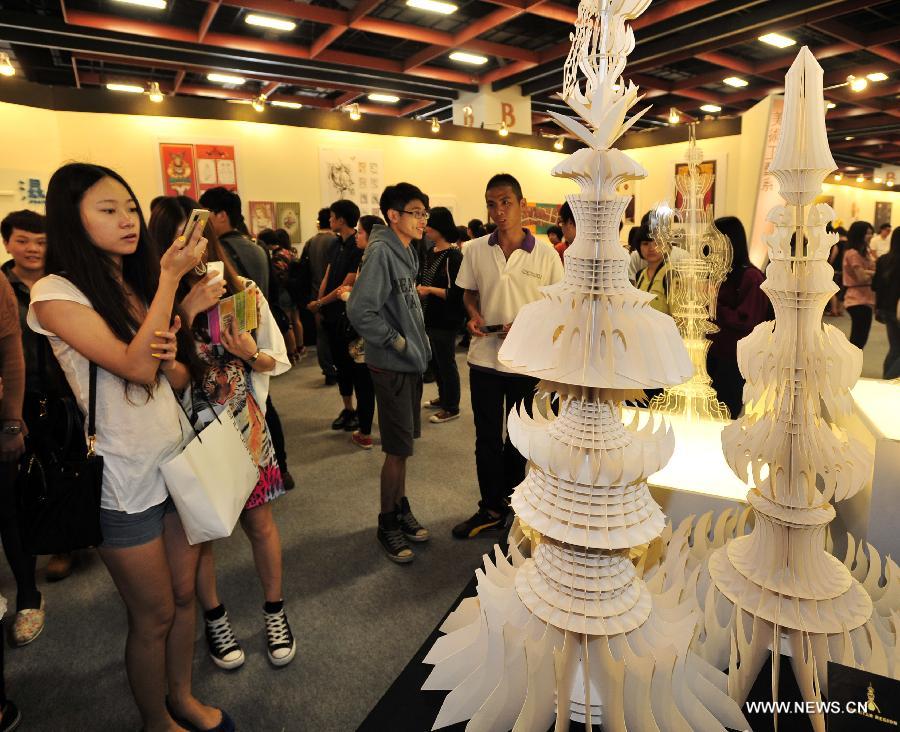 Visitors view paper-made models at the 2013 Youth Designers' Exhibition (YODEX) in Taipei, southeast China's Taiwan, May 17, 2013. The 2013 YODEX, opening Friday in Taipei, attracted over 8,400 designers. (Xinhua/Wu Ching-teng)  