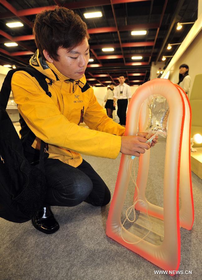 A man shows an inflatable shelf for intravenous drip at the 2013 Youth Designers' Exhibition (YODEX) in Taipei, southeast China's Taiwan, May 17, 2013. The 2013 YODEX, opening Friday in Taipei, attracted over 8,400 designers. (Xinhua/Wu Ching-teng)  