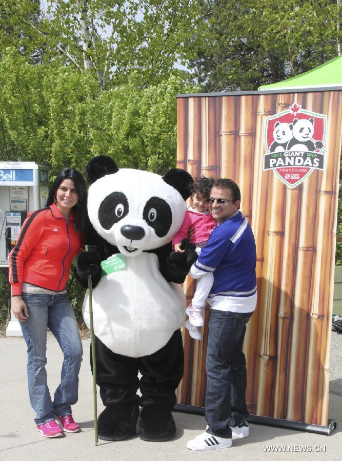Visitors pose with a giant panda model at the Toronto Zoo in Toronto, Canada, on May 18, 2013. Er Shun and Da Mao, the two giant pandas on a 10-year loan from China, made their first public appearance in their new home at the Toronto Zoo on Saturday. (Xinhua/Zhang Ziqian) 