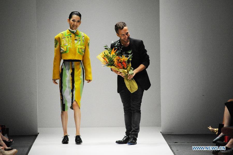 British designer Peter Pilotto (R)greets the audience after his fashion show during the Audi Fashion Festival held in Singapore's Marina Bay, May 18, 2013. (Xinhua/Then Chih Wey) 