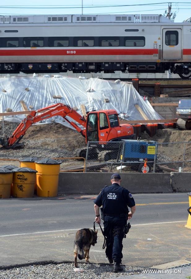 A policeman works at the site of a Metro North train collision in Fairfield, Connecticut, the United States, on May 18, 2013. Investigators have begun their probe into the commuter train collision which took place in the U.S. state of Connecticut during Friday evening rush hour, leaving more than 70 injuries, government officials said in a press briefing Saturday. (Xinhua/Wang Lei) 