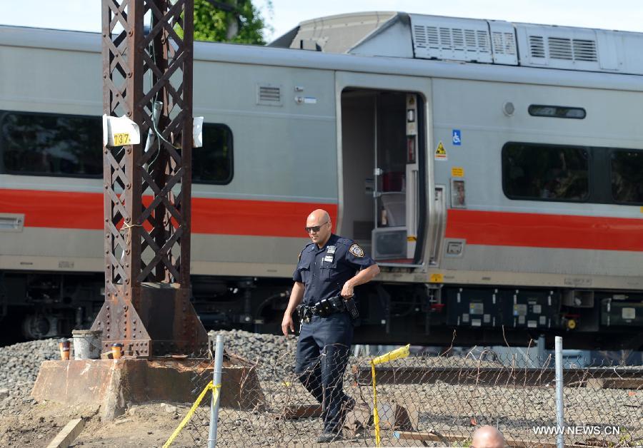 A policeman works at the site of a Metro North train collision in Fairfield, Connecticut, the United States, on May 18, 2013. Investigators have begun their probe into the commuter train collision which took place in the U.S. state of Connecticut during Friday evening rush hour, leaving more than 70 injuries, government officials said in a press briefing Saturday. (Xinhua/Wang Lei) 