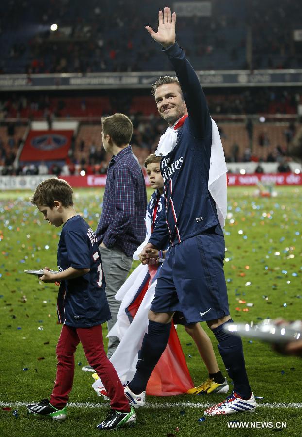 Paris Saint-Germain's English midfielder David Beckham waves to the crowd with his sons, Brooklyn, Romeo and Cruz during the celebration for winning the French League 1 title after the League 1 football match between Paris St Germain and Brest at Parc des Princes stadium in Paris on May 18, 2013. (Xinhua/Wang Lili)