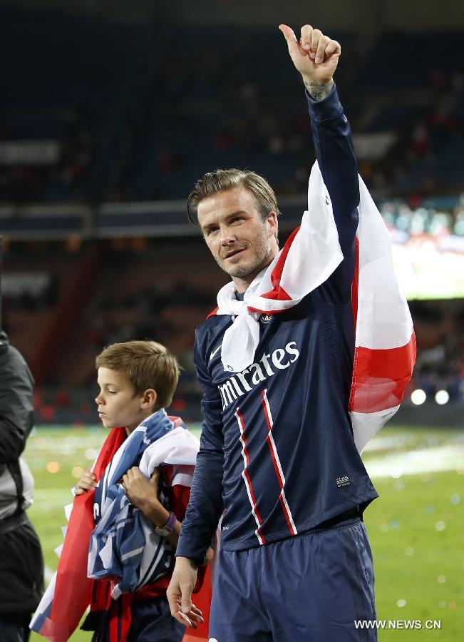 Paris Saint-Germain's English midfielder David Beckham gestures to the crowd with his son Romeo during the celebration for winning the French League 1 title after the League 1 football match between Paris St Germain and Brest at Parc des Princes stadium in Paris on May 18, 2013. (Xinhua/Wang Lili)