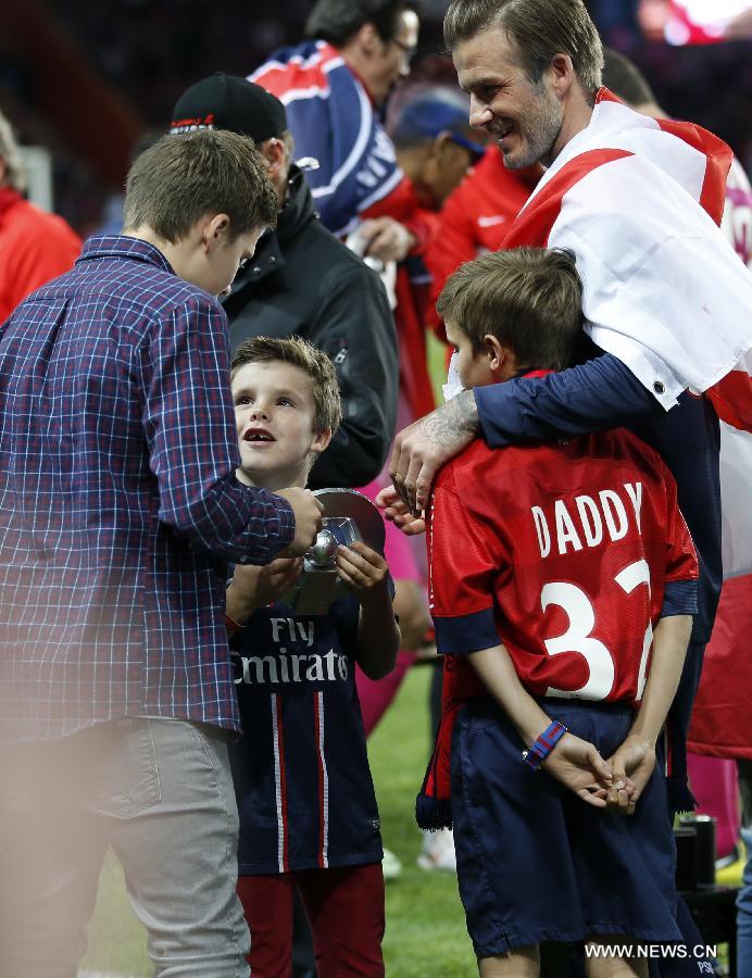 Paris Saint-Germain's English midfielder David Beckham shows his trophy to his three sons, Brooklyn (L), Romeo (R) and Cruz (C) during the celebration for winning the French League 1 title after the League 1 football match between Paris St Germain and Brest at Parc des Princes stadium in Paris on May 18, 2013. (Xinhua/Wang Lili)