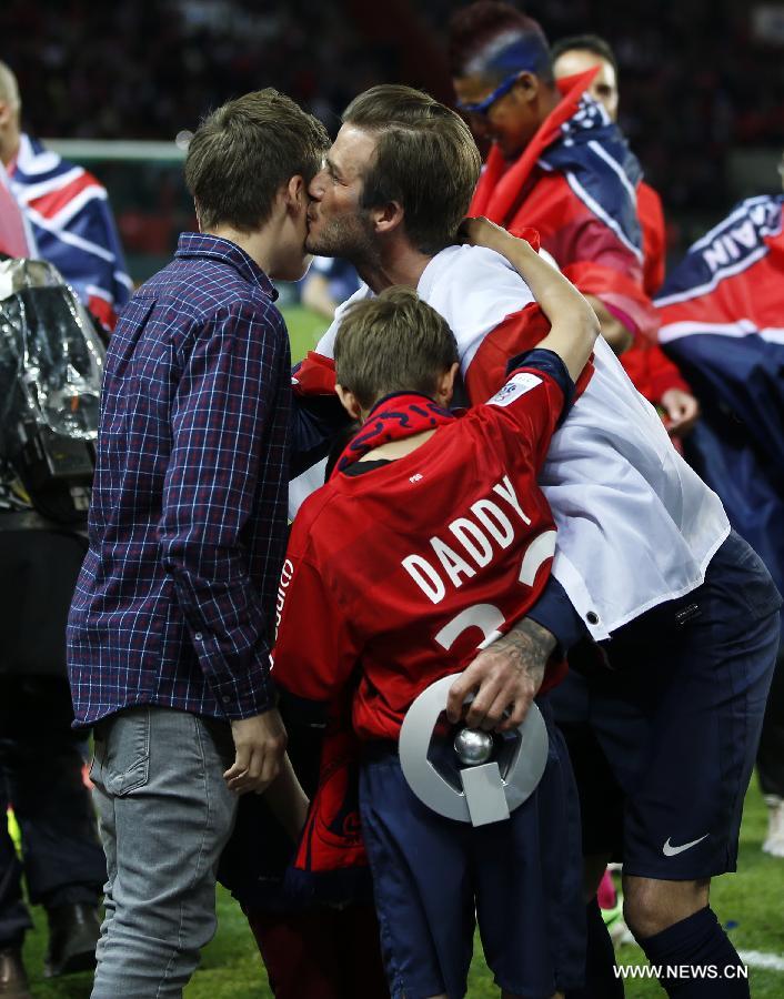 Paris Saint-Germain's English midfielder David Beckham kisses his son Brooklyn, Romeo and Cruz during the celebration for winning the French League 1 title after the League 1 football match between Paris St Germain and Brest at Parc des Princes stadium in Paris on May 18, 2013. (Xinhua/Wang Lili) 