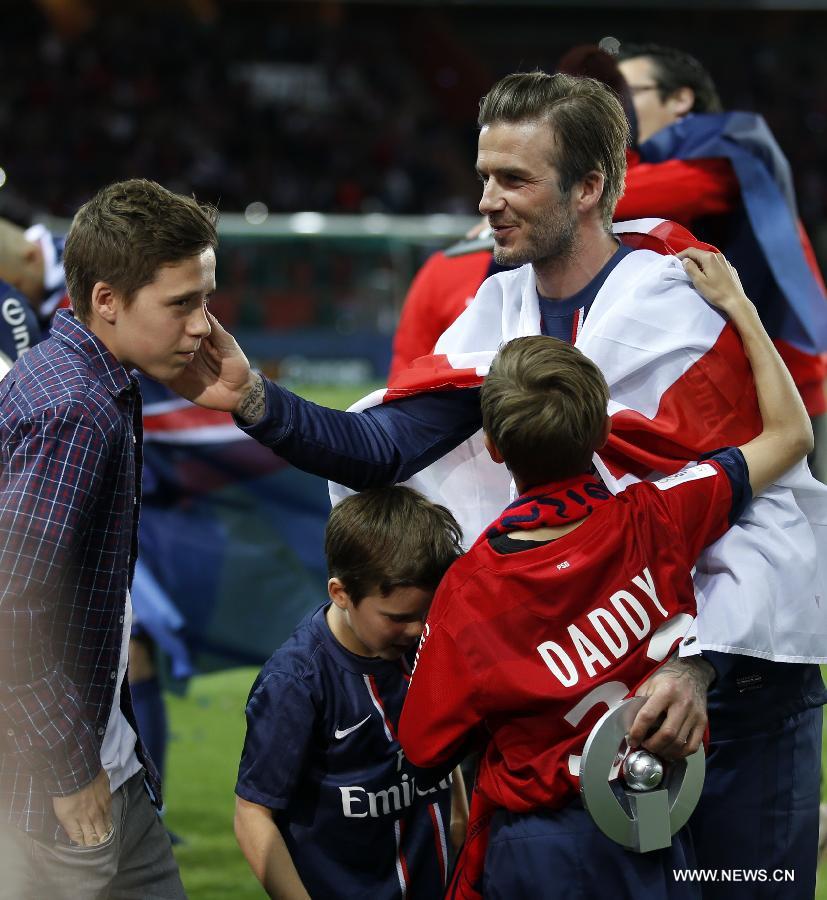 Paris Saint-Germain's English midfielder David Beckham talks with his sons, Brooklyn (L), Romeo (R) and Cruz (C) during the celebration for winning the French League 1 title after the League 1 football match between Paris St Germain and Brest at Parc des Princes stadium in Paris on May 18, 2013. (Xinhua/Wang Lili)