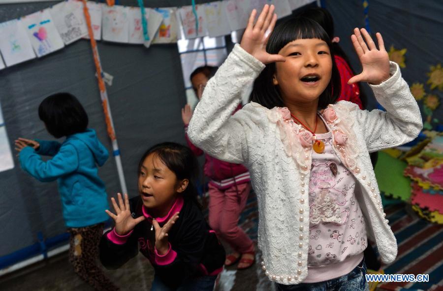 Children take a dance class in a temporarily-erected tent in Lushan County, southwest China's Sichuan Province, May 17, 2013. More than 100 children frequently participate in extra-curricular activities at this temporary school, which was opened on April 29 by volunteers and provides reading, painting and dancing classes to local children. The county was jolted by a 7.0-magnitude earthquake on April 20. (Xinhua/Liu Xiao) 