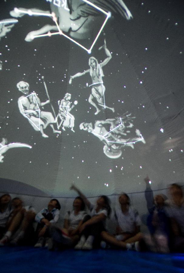 Visitors look at a presentation of a simulative star field during a science exhibition in Beijing, capital of China, May 19, 2013. The exhibition is a part of the National Science and Technology Week and will last till May 25. (Xinhua/Luo Xiaoguang) 