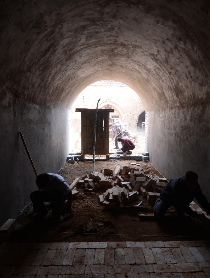 Construction workers renovate a sunken courtyard in Qucun Village of Zhangbian Township in Shaanxian County, central China's Henan Province, May 18, 2013. The sunken courtyard, a kind of traditional residential construction in west Henan, has a high value in the study of local histroy, architecture, geology and sociology. The Qucun Village has 115 sunken courtyards, most of which are under protective reconstruction. (Xinhua/Zhao Peng)