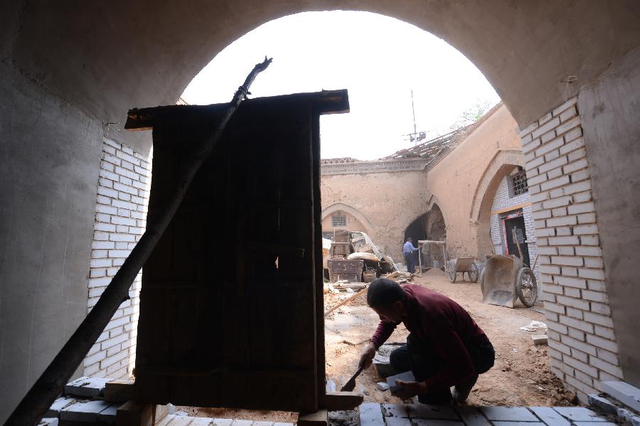 Construction workers renovate a sunken courtyard in Qucun Village of Zhangbian Township in Shaanxian County, central China's Henan Province, May 18, 2013. The sunken courtyard, a kind of traditional residential construction in west Henan, has a high value in the study of local histroy, architecture, geology and sociology. The Qucun Village has 115 sunken courtyards, most of which are under protective reconstruction. (Xinhua/Zhao Peng)