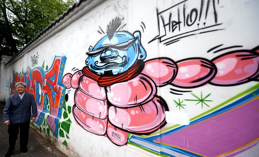 Photo taken on May 19, 2013 shows a wall decorated with graffiti in Nanchang, capital of east China's Jiangxi Province. Two graduates from the Academy of Arts and Design in Hunan University of Science and Technology designed those graffiti to express their opinions of fashion. (Xinhua/Zhou Ke)