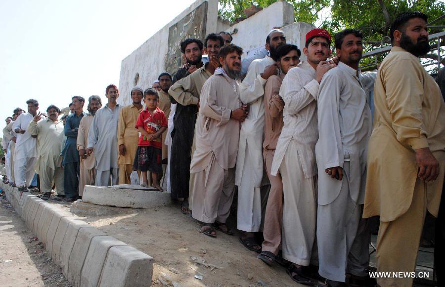 Pakistanis stand in a queue outside a polling station during the partial re-run election in southern Pakistani port city of Karachi, May 19, 2013. Re-polling on a parliamentary seat started in Pakistan's port city of Karachi Sunday morning following allegations of rigging, officials said. (Xinhua/Arshad) 