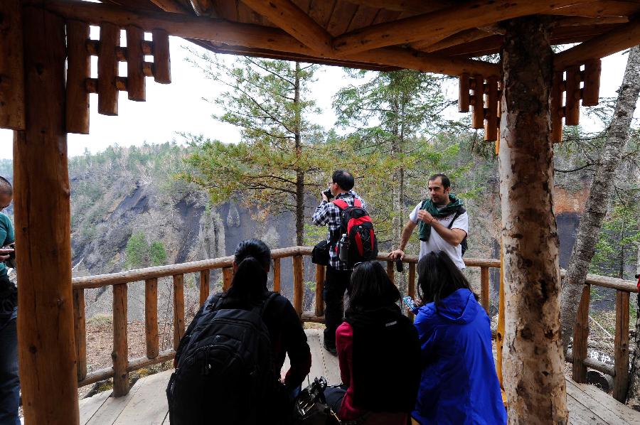 Tourists rest at the viewing deck of a scenic spot in the Changbai Mountain in Changchun City, northeast China's Jilin Province, May 18, 2013. (Xinhua/Xu Chang)
