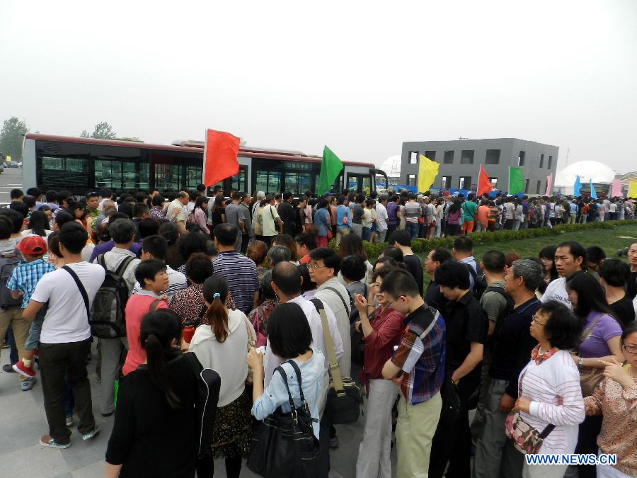 Visitors line up to take buses to the garden show park during the 9th China (Beijing) International Garden Expo in Beijing, capital of China, May 18, 2013. The expo opened in southwestern Fengtai district in Beijing on Saturday and will last till Nov. 18, 2013. Garden designs from 69 Chinese cities and 29 countries will be presented. (Xinhua/Wang Zhen)