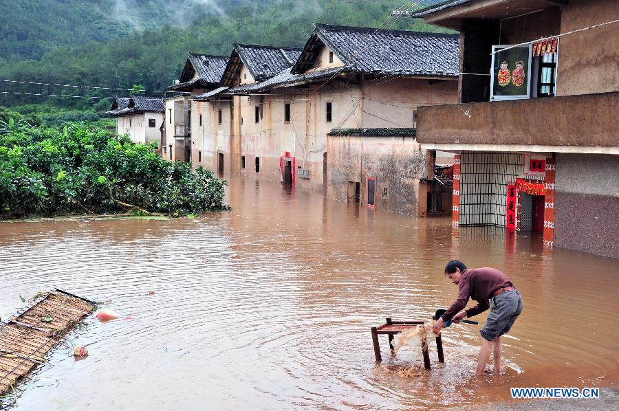 A villager cleans furniture in Baokeng Village of Meixian County in south China's Guangdong Province, May 19, 2013. The National Meteorological Center (NMC) Sunday issued a blue alert, the lowest level in a four-color warning system, for rainstorms in the south in the next three days. (Xinhua/Zhong Xiaofeng)