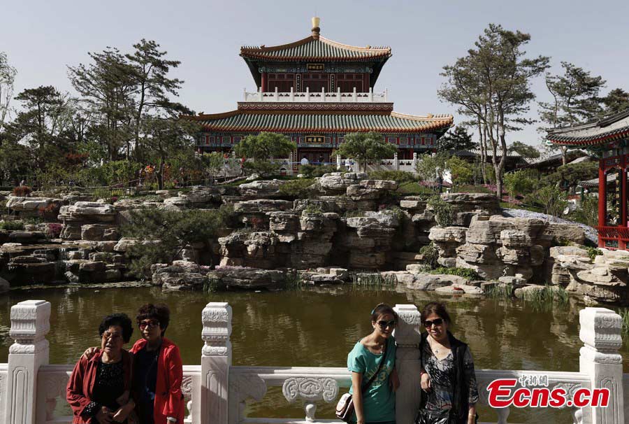 Visitors pose for pictures at the Garden Expo Park in Fengtai District, Beijing, May 19, 2013. The Ninth China (Beijing) International Garden Expo kicked off on Saturday. Garden designs from 69 Chinese cities and 29 countries will be presented. (CNS/Liu Guanguan)