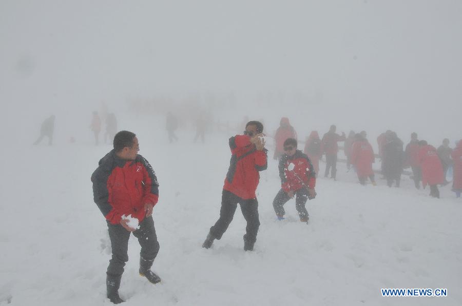Tourists play with the snow at the Changbai Mountain in northeast China's Jilin Province, May 19, 2013. (Xinhua/Zhang Jian)