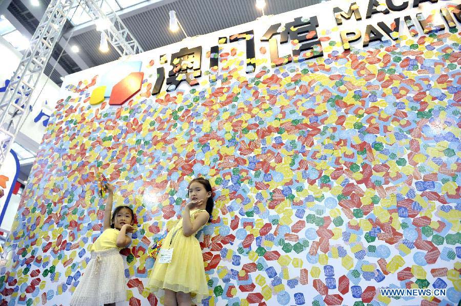 Two girls pose for photo in front of the Macao Pavilion during the 9th China (Shenzhen) International Cultural Industries Fair in Shenzhen, south China's Guangdong Province, May 19, 2013. The four-day event closed on Monday. The transaction volume in the first three days grew 15.85 percent year on year. (Xinhua/Liang Xu)