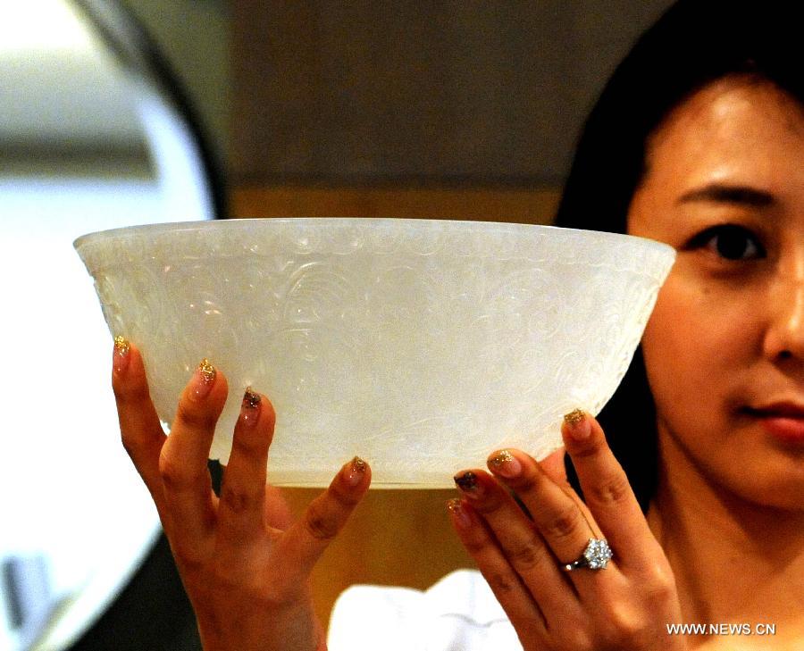 A worker displays a lined jade bowl made in the Qing Dynasty (1644-1911) during the preview of Est-Ouest Auctions' spring season auction in south China's Hong Kong, May 20, 2013. The preview of Est-Ouest Auctions' 2013 spring season auction opened here on Monday, and the auction will be held in Hong Kong on May 26. (Xinhua/Huang Benqiang)