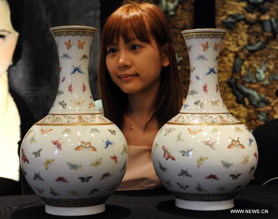 A worker displays vases made in the Qing Dynasty (1644-1911) during the preview of the Est-Ouest Auctions' spring season auction in south China's Hong Kong, May 20, 2013. The preview of the Est-Ouest Auctions' 2013 spring season auction opened here on Monday, and the auction will be held in Hong Kong on May 26. (Xinhua/Huang Benqiang)